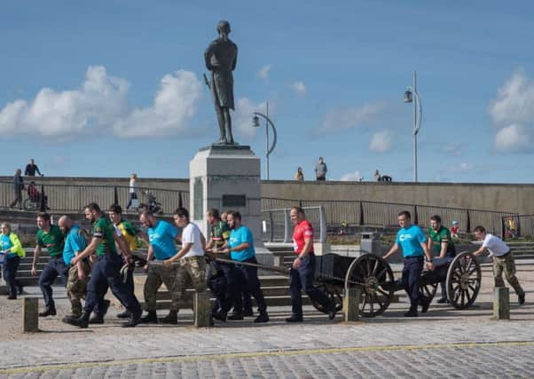 The team passes the Nelson statue in Old Portsmouth. Picture: Keith Woodland (171022-0023)