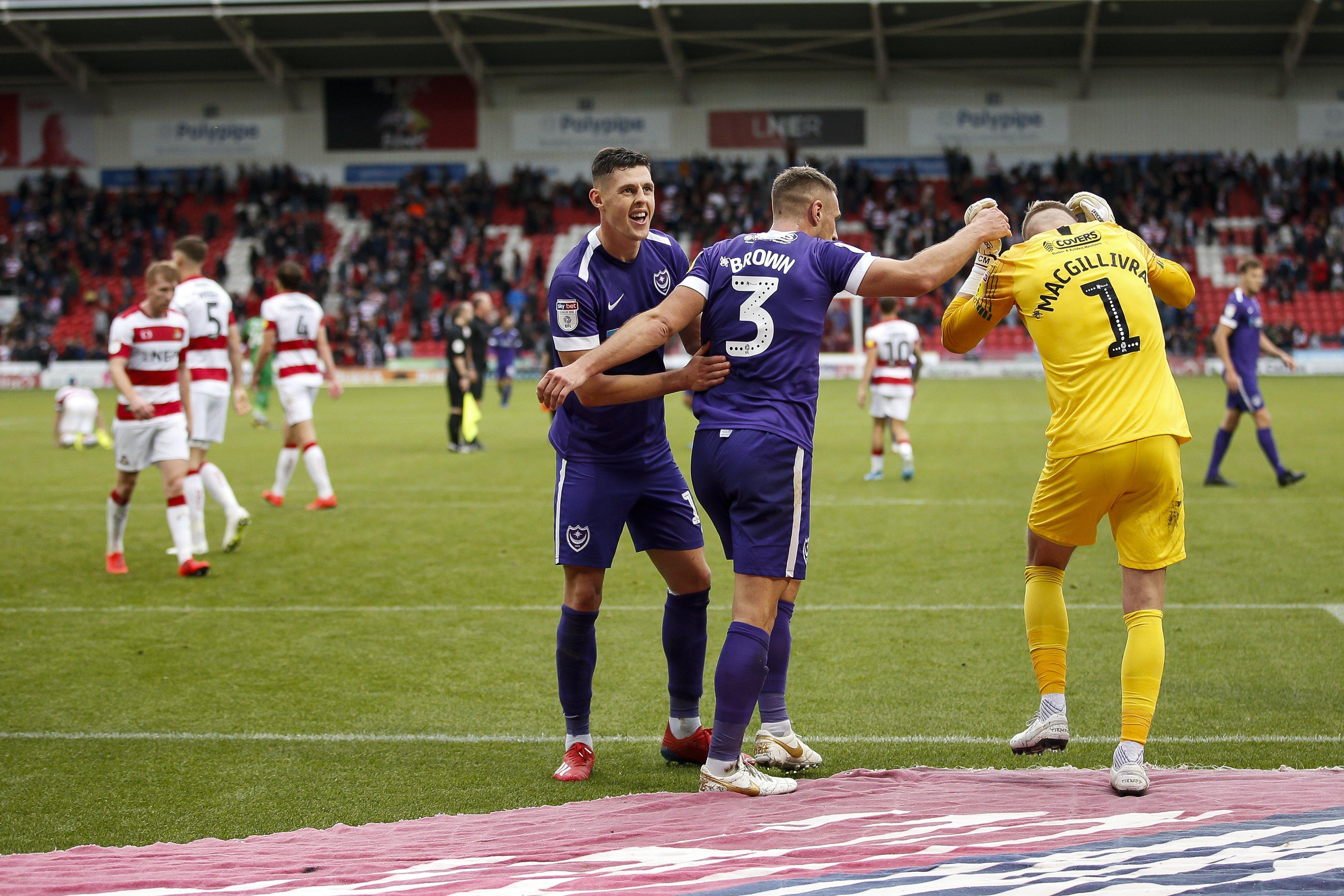 James Bolton, left, and Lee Brown, centre, celebrate with Craig MacGillivray following Pompey's win at Doncaster. Picture: Daniel Chesterton/PinPep