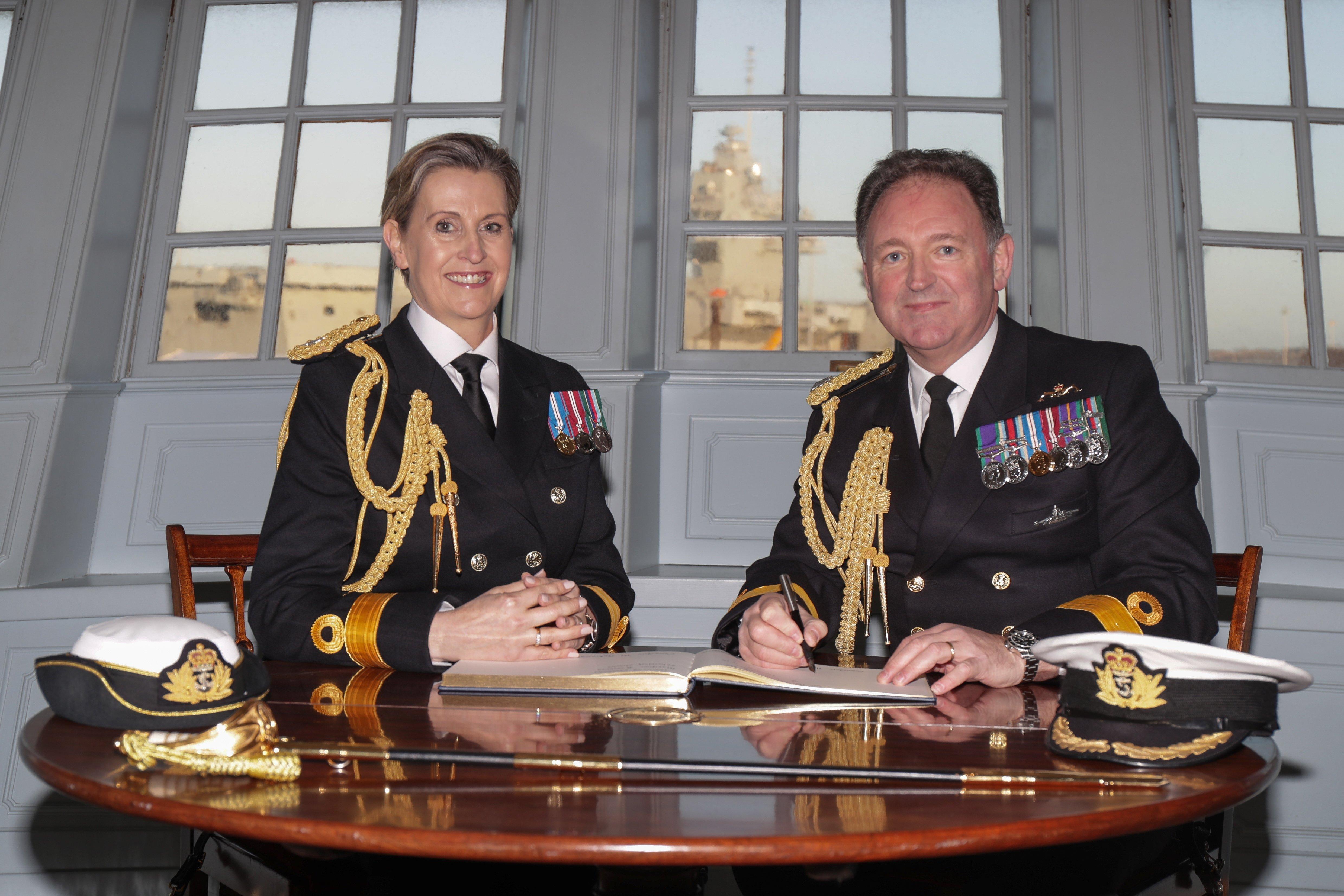 Commodore Robinson and Commodore Quinn signing the official documents for the Commander maritime reserve supersession ceremony held on board HMS Victory