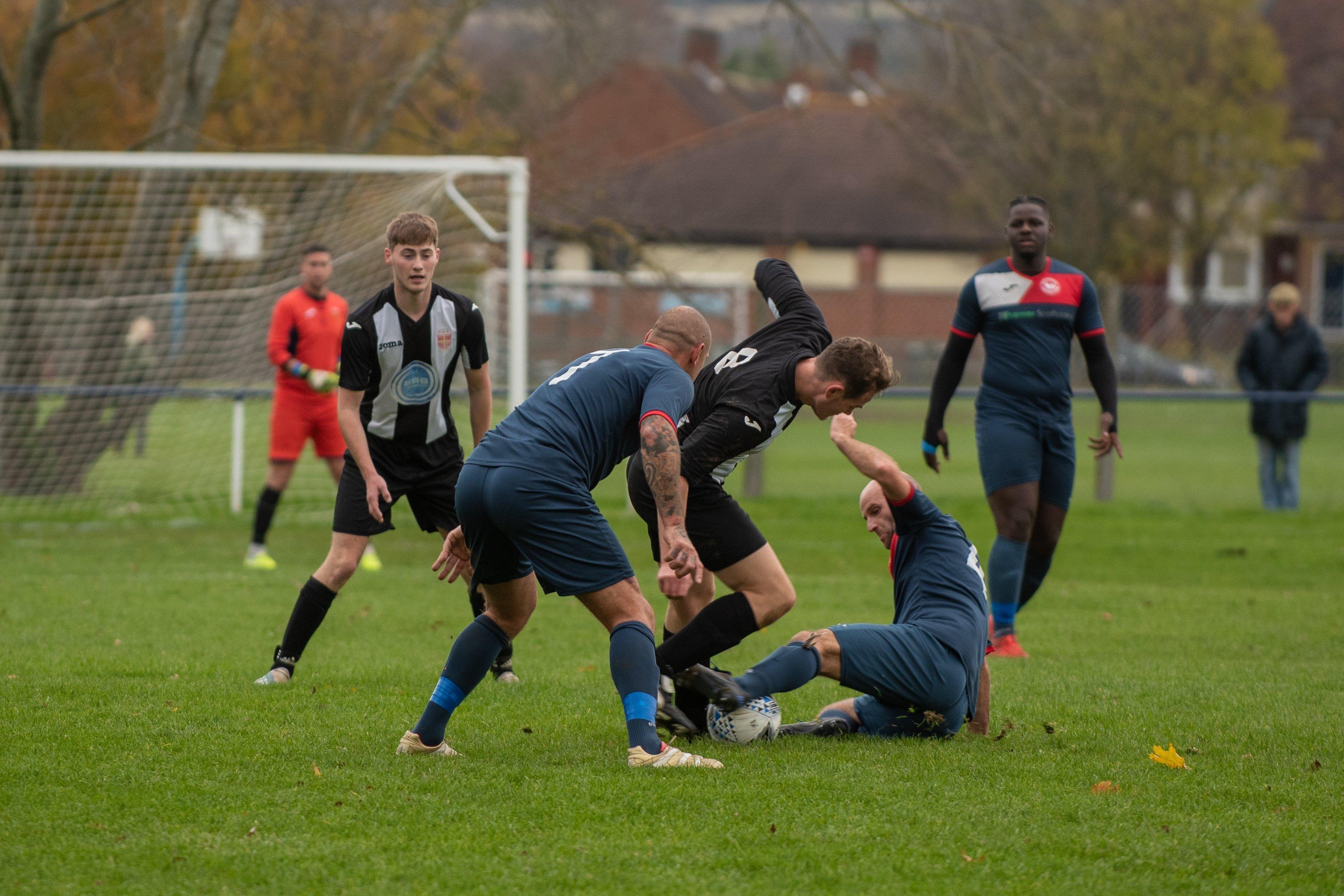 Hayling's Matt Topple is tackled by Paulsgrove's John Cripps as Aaron Fennemore looks on