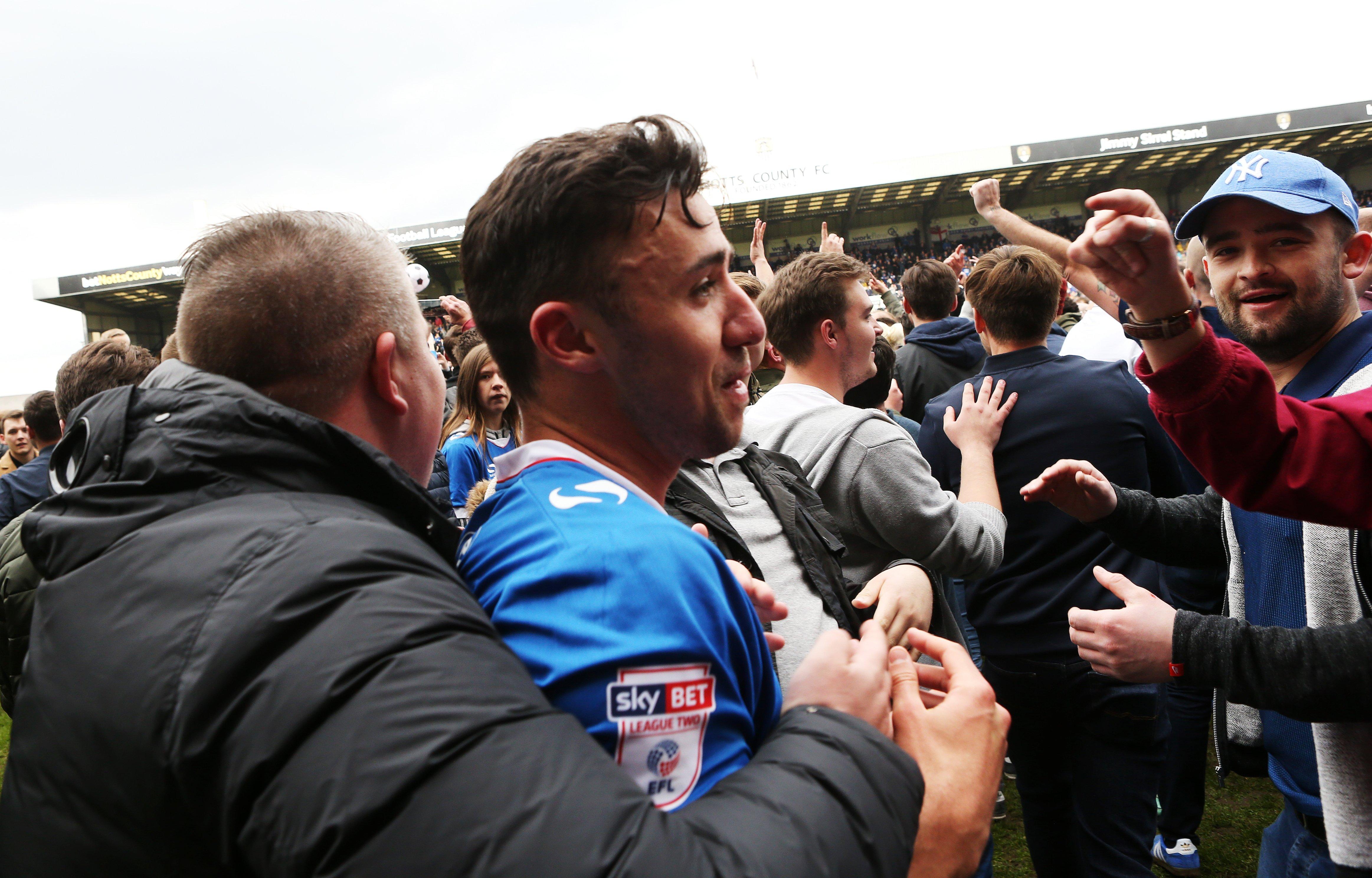 Enda Stevens celebrates Pompey's promotion from League Two at Notts County with the Fratton faithful. Picture: Joe Pepler