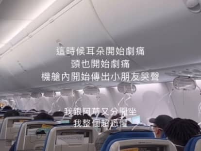 Passengers hold oxygen masks to their faces after their plane dropped 26,900ft.