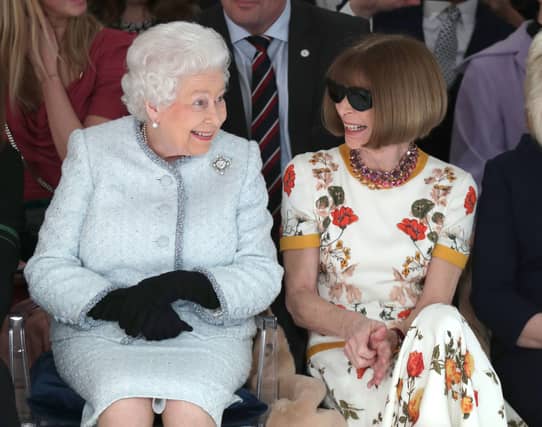 LONDON, ENGLAND - FEBRUARY 20: Queen Elizabeth II sits next to Anna Wintour as they view Richard Quinn’s runway show before presenting him with the inaugural Queen Elizabeth II Award for British Design as she visits London Fashion Week’s BFC Show Space on February 20, 2018 in London, United Kingdom. (Photo by Yui Mok - Pool/Getty Images)