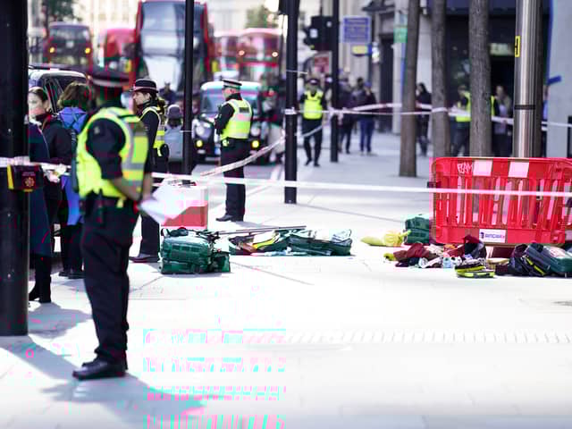 Police officers at the scene after three people have been taken to hospital following reports of stabbings at Bishopsgate in London. Picture date: Thursday October 6, 2022.