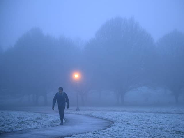A walker makes their way through fog on a frosty morning at Primrose Hill in north London. (Photo by Justin TALLIS / AFP) (Photo by JUSTIN TALLIS/AFP via Getty Images)