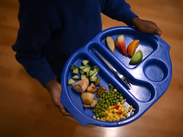 A child carries a tray with food during lunch-break at St Mary’s RC Primary School, in Battersea, south London.