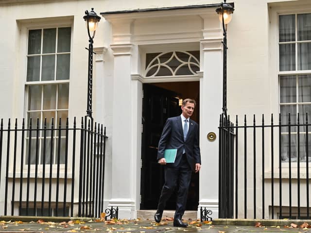 Britain's Chancellor of the Exchequer Jeremy Hunt walks out of Number 11 Downing Street 