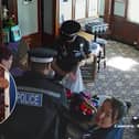 CCTV footage shows police storming a couple's Essex pub and seizing their golliwog dolls, saying the toys were a suspected hate crime (Photos: SWNS)