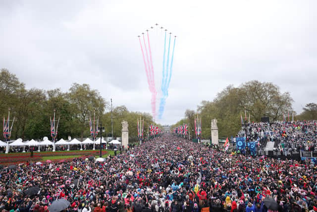 Crowds made their way down the Mall and towards Buckingham Palace, to greet to the new King and Queen at the balcony of Buckingham Palace. Shortly after the royal arrival on the balcony, a traditional Red Arrow flyover - which had been scaled back due to weather - brightened the rainy skies over London. (Credit: Getty Images)