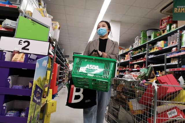 A shopper wears a protective mask as she walks down an aisle in a supermarket (Getty Images)