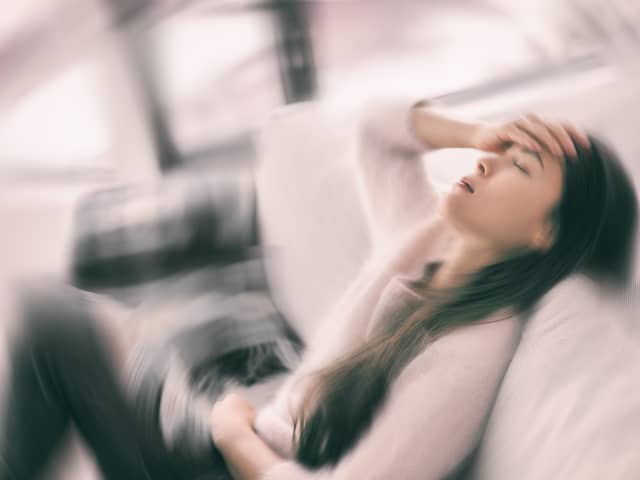 Stock image of woman holding her head in pain