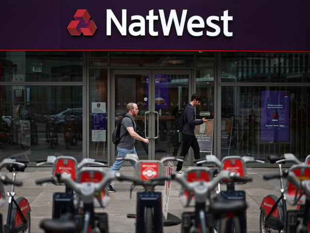 Pedestrians walk past a branch of a NatWest bank in London.