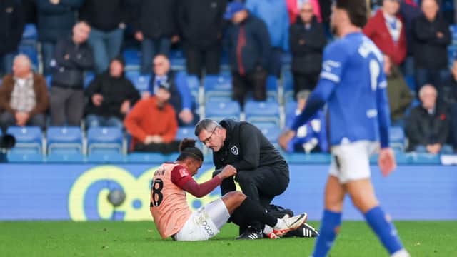 Tino Anjorin receives treatment at Chesterfield on Sunday after suffering a hamstring injury