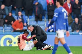 Tino Anjorin receives treatment at Chesterfield on Sunday after suffering a hamstring injury