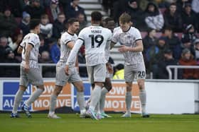 Sean Raggett is congratulated by his Pompey team-mates following his opener against Northampton on Saturday.