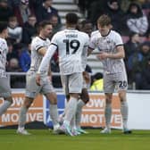 Sean Raggett is congratulated by his Pompey team-mates following his opener against Northampton on Saturday.