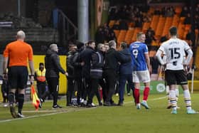 A fan is stopped by officials and staff from both teams after he attempted to get to referee Craig Hicks in Pompey's win at Port Vale. Pic: Jason Brown