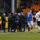 A fan is stopped by officials and staff from both teams after he attempted to get to referee Craig Hicks in Pompey's win at Port Vale. Pic: Jason Brown