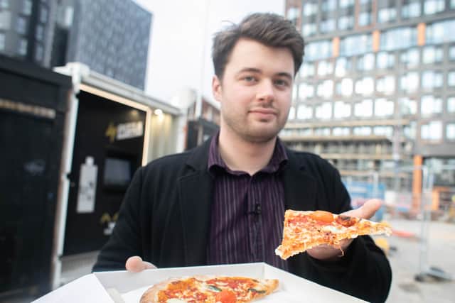 Reporter Joe Buncle tries pizza from a Pizza Rebellion vending machine.