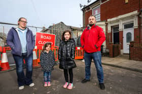 Alan Orbell and Sam King with their children, Orla, 4, second left, and Freyja, 9, in front of their house in Langford Road, Fratton, adjacent to the site of a house that collapsed in December 2022 Picture: Chris Moorhouse 