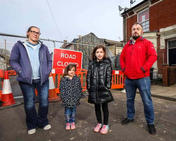 Alan Orbell and Sam King with their children, Orla, 4, second left, and Freyja, 9, in front of their house in Langford Road, Fratton, adjacent to the site of a house that collapsed in December 2022 Picture: Chris Moorhouse 