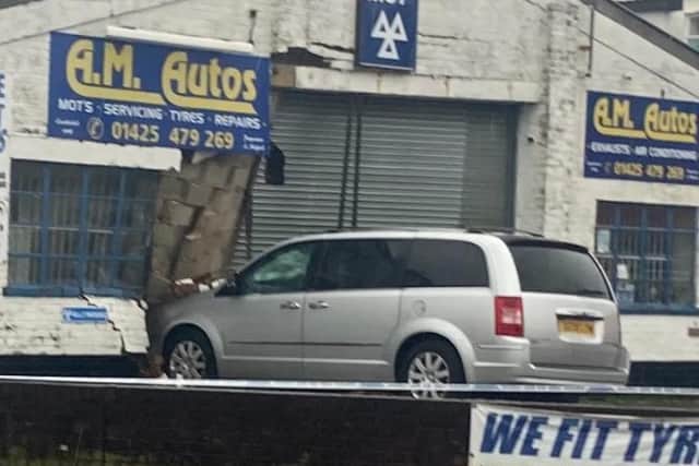 Car nestled into wall of A M Autos car garage