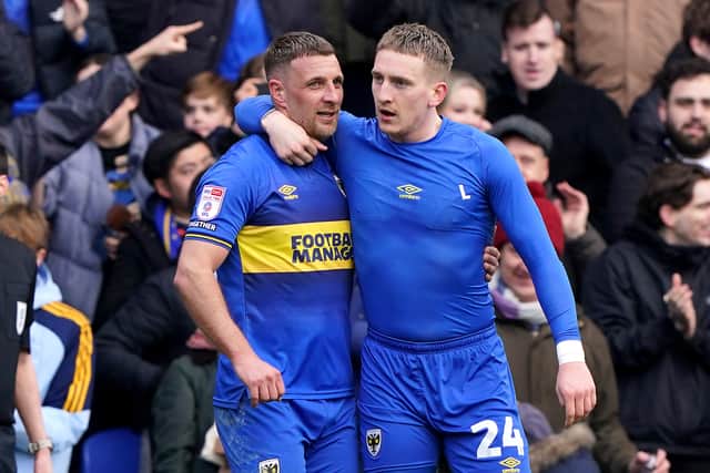 Former Pompey pair Ronan Curtis and Lee Brown celebrate the late AFC Wimbledon winner against MK Dons. Pic: PA