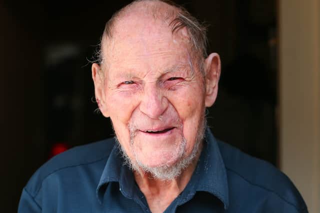 Laurie Blythe, of Fratton, on his 100th birthday. He is pictured holding his card from the King and Queen
Picture: Chris  Moorhouse