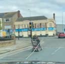 A man tows a metal fence from his mobility scooter in Grimsby. The man was spotted dragging the fence along as he stopped at traffic lights.
