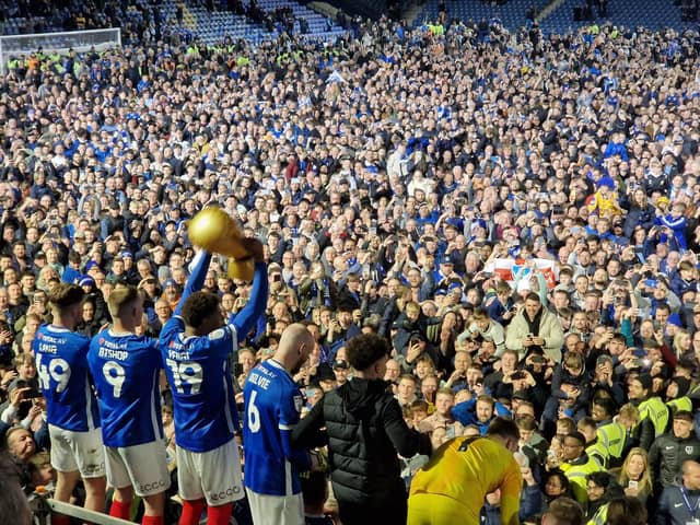 Players and fans celebrating on the pitch after Pompey's victory