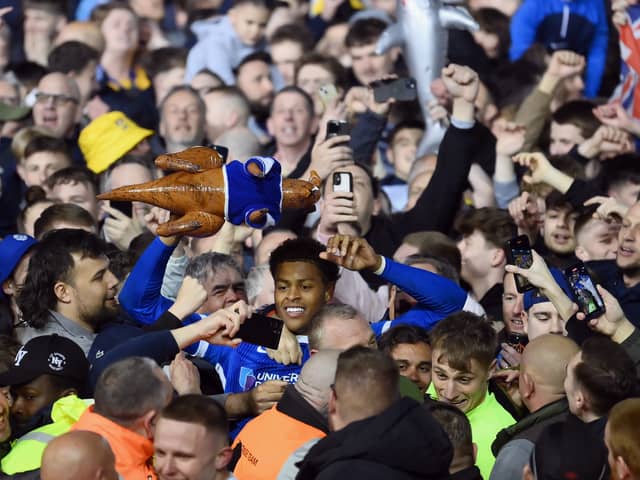 Kusini Yengi joins Pompey fans in celebration after the title win over Barnsley. Pic: Getty