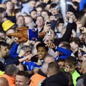Kusini Yengi joins Pompey fans in celebration after the title win over Barnsley. Pic: Getty