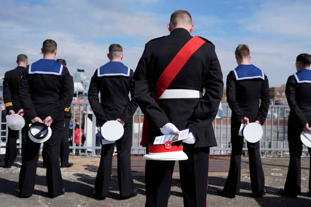 Members of the Royal Navy remove their caps during the Anzac Day service of remembrance on board HMS M.33, the sole-surviving ship from the Gallipoli campaign