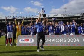 Manchester City's Pompey loanee Alex Robertson lifts the League One trophy aloft on Saturday against Wigan Athletic. Pic: Jason Brown.