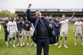 Pompey boss John Mousinho and his players celebrate at Lincoln City today.