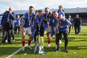 Joe Rafferty, left, with Zak Swanson, Colby Bishop and Tom Lowery after Pompey lifted the League One championship trophy