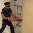 A police officer breaking the door of a flat in Blake Court, South Street, Gosport, where suspected Class C drugs were seized during a warrant. Picture: Gosport Police.