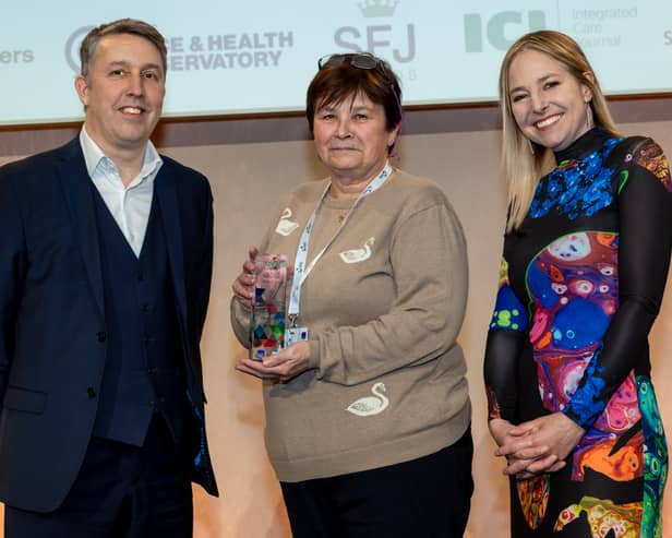 Tina Jackson collects her Our Health Heroes Award from Michael Brodie, chief executive of NHS Business Services Authority, and ceremony host Alice Roberts.