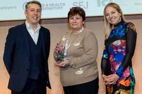 Tina Jackson collects her Our Health Heroes Award from Michael Brodie, chief executive of NHS Business Services Authority, and ceremony host Alice Roberts.