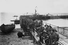 Troops line up on a temporary pier in Southsea as they wait to embark