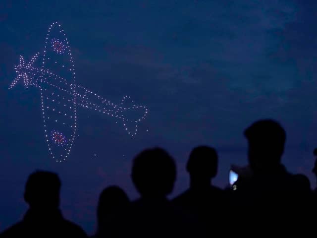 Drones make a Spitfire during a drone display telling the story of D-Day above the coastline in Southsea