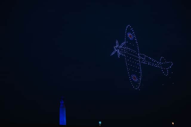 A Spitfire flying across the sky as the drones formed beautiful shapes and colours over Portsmouth for the 80th anniversary of D-Day. Picture: Sarah Standing