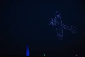 A Spitfire flying across the sky as the drones formed beautiful shapes and colours over Portsmouth for the 80th anniversary of D-Day. Picture: Sarah Standing