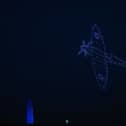 A Spitfire flying across the sky as the drones formed beautiful shapes and colours over Portsmouth for the 80th anniversary of D-Day. Picture: Sarah Standing