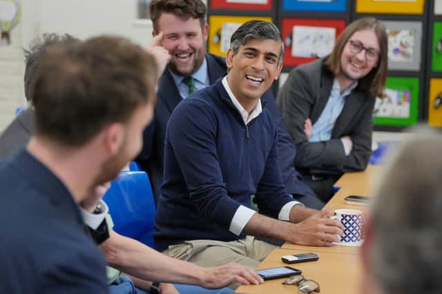 Prime Minister Rishi Sunak speaks to members of the media during a huddle