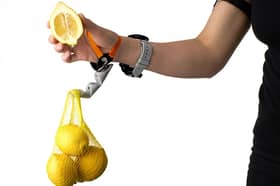 A Third Thumb being used to hold a bag of lemons.