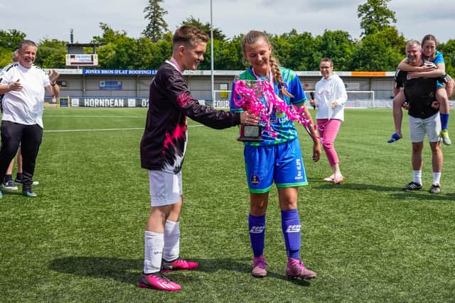 Jacob Lee handing over the trophy to the skipper of City Ladies FC. Picture: Jason Brown.