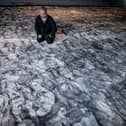 Peter Codling, a renowned Portsmouth-based artist who is currently finalising his extraordinary piece of art, hand-drawn on a replica sail of HMS Victory on Thursday 18th July 2024Pictured: Pete Codling with his artwork at the Historic Dockyard Picture: Habibur Rahman