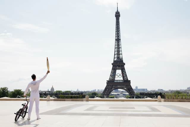 Torch bearer Matthias Dandois, French bicycle rider, poses for a photo with the Olympic Torch with the Eiffel Tower in view (Photo: Maja Hitij/Getty Images)