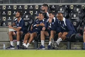 Pompey boss John Mousinho, centre, during the midweek trip to MK Dons